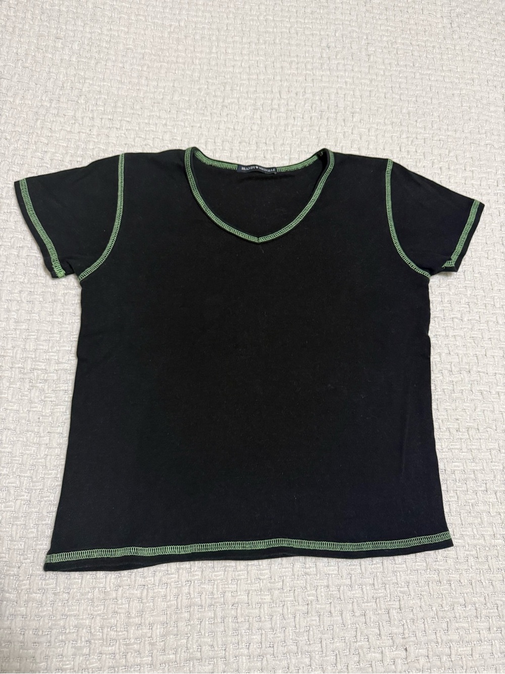 Brandy Melville women’s black baby tee with green hem.  Fits like a Large.